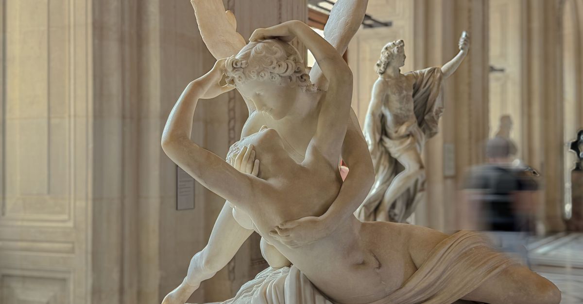 Elegant marble sculpture depicting Psyche Revived by Cupid's Kiss at a museum.